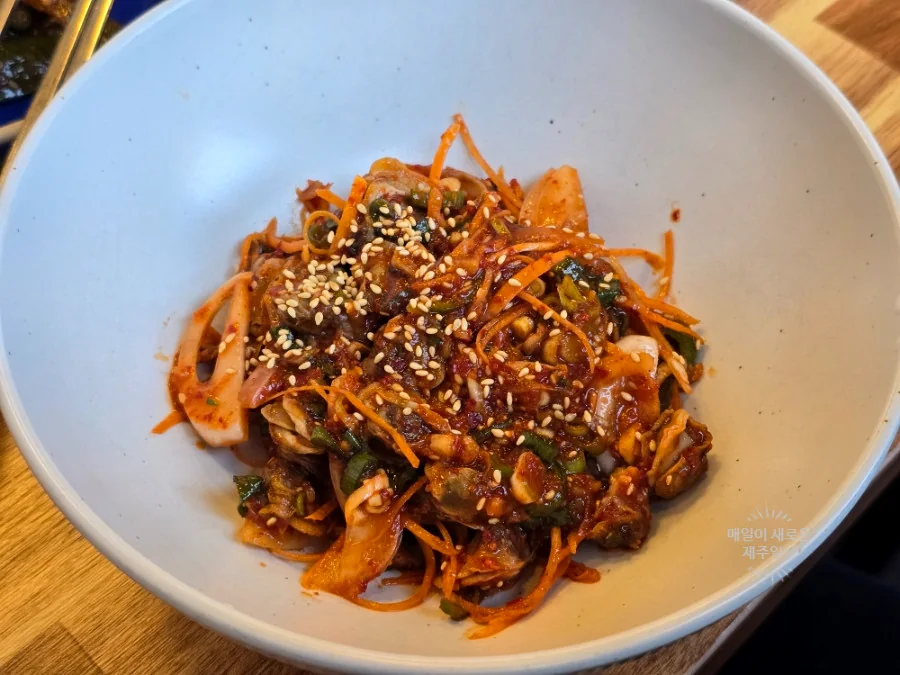 참기름과 채소를 곁들인 꼬막 돌솥비빔밥